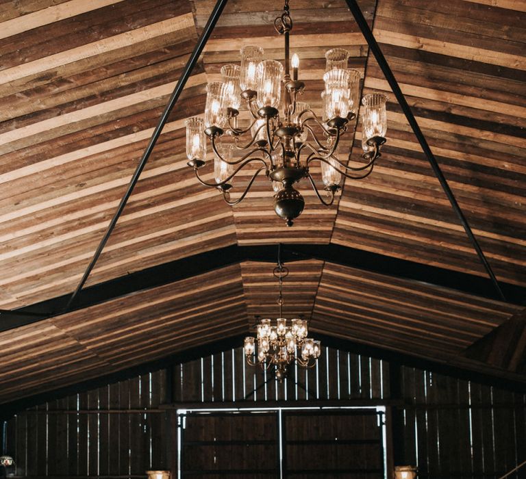 Rustic Luxe Barn Wedding Venue with Chandelier , Wooden Tables and Greenery Table Runners