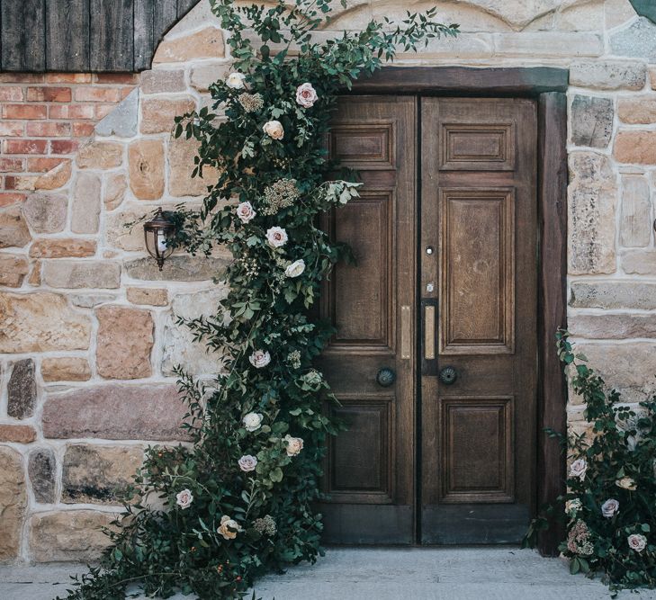 Wooden Door with Greenery and White Flower Arrangement by Number Twenty Seven