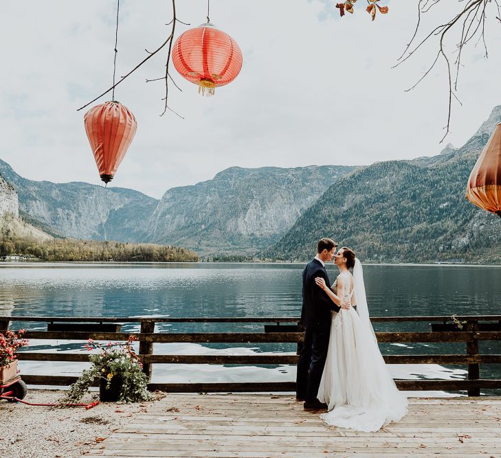 Bride and Groom Portrait By The Waters Edge with Hanging Lanterns in The Tree