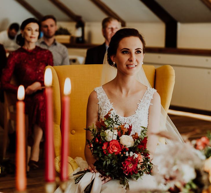 Bride Sitting Down During The Wedding Ceremony with Tapper Candles