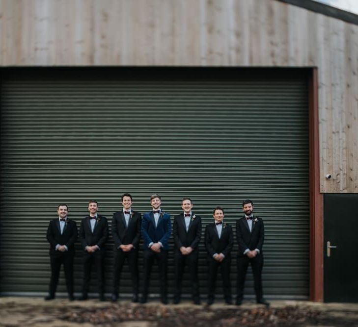 Groom wearing navy velvet suit with his groomsmen for New Years eve ceremony