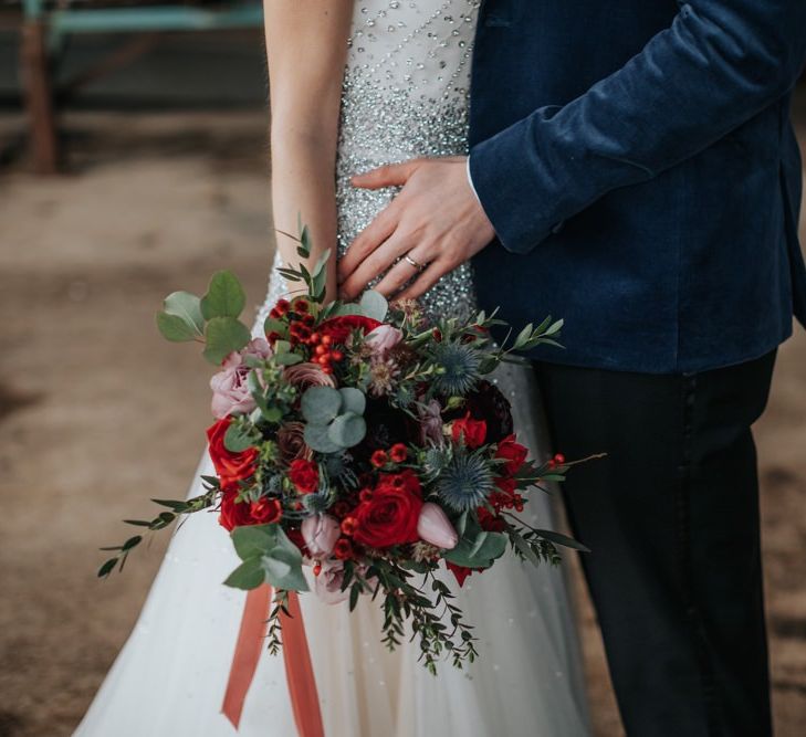 Close up details of winter inspired floral bouquet with red roses at New Years eve celebration