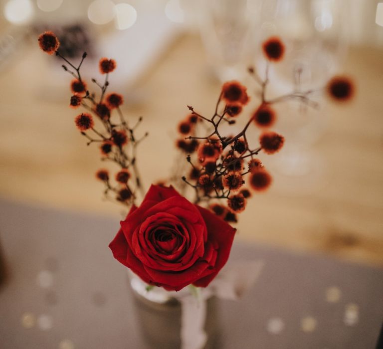 Red rose floral table decor at winter reception with fairy lights