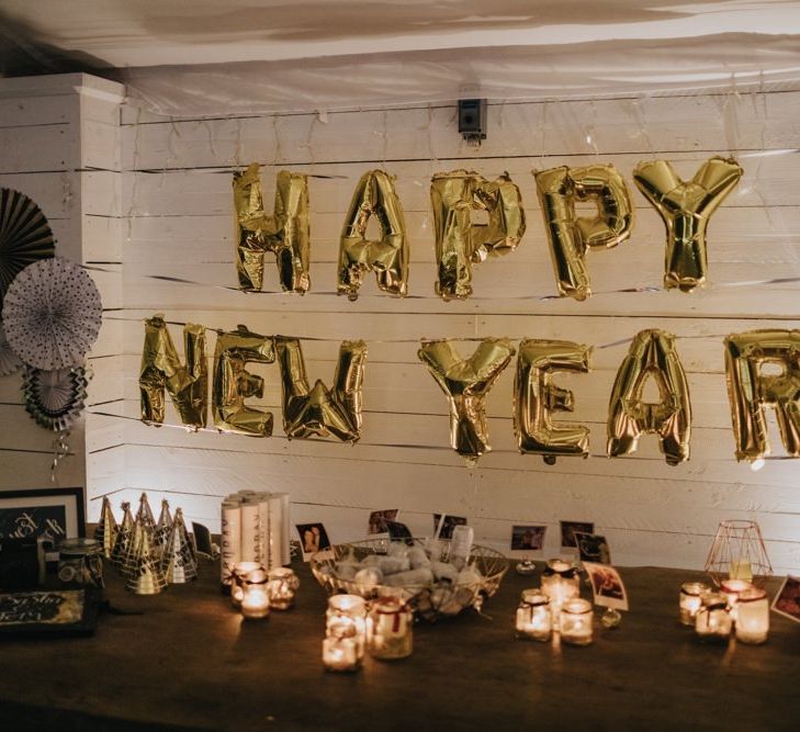 'Happy New Year' balloons for marquee winter reception with fairy lights and candles