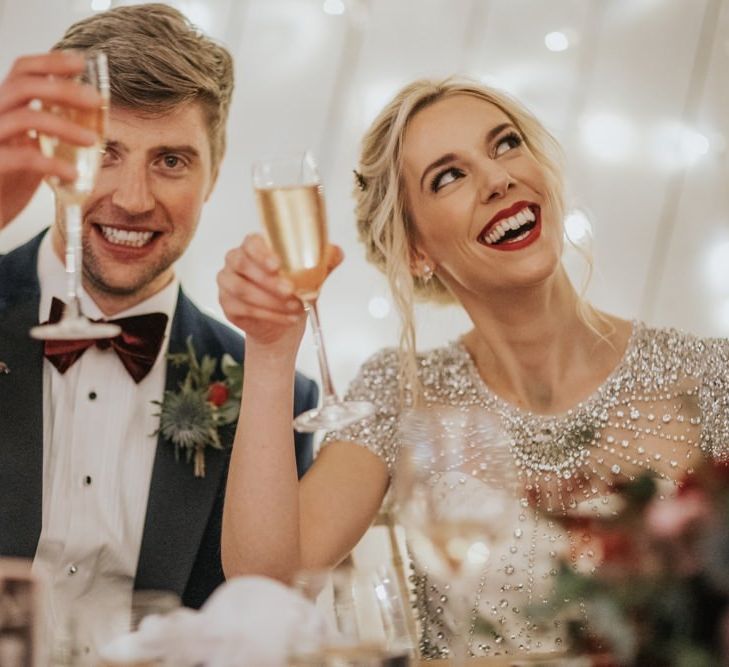 Bride wearing an embellished wedding dress and classic red lip for winter wedding reception