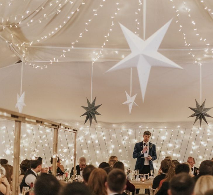 Grooms speech at marquee winter reception styling with star decor and fairy lights for New Years eve celebration