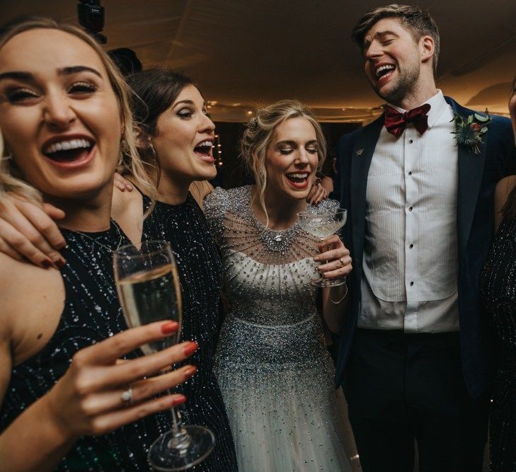 Bride wearing embellished wedding dress and bridesmaids in black dress with black tie winter wedding