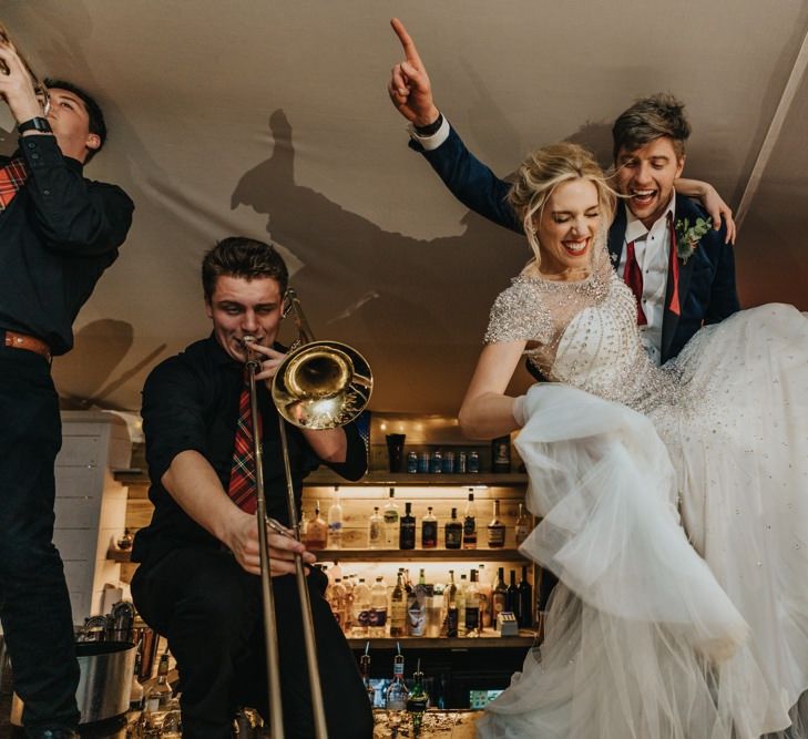 Bride and groom party into the new year dancing on the bar with their band