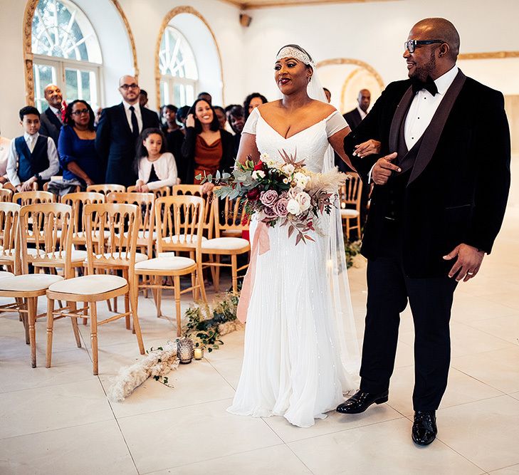 Black Bride in Juliet Cap Veil and Eliza Jane Howell Wedding Dress Walking Down the Aisle with Her Dad in a Tuxedo