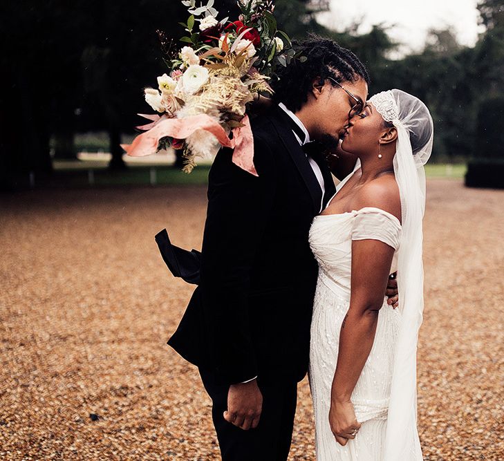 Black Bride in Juliet Cap Veil and Eliza Jane Howell Wedding Dress and Groom in Tuxedo Kissing