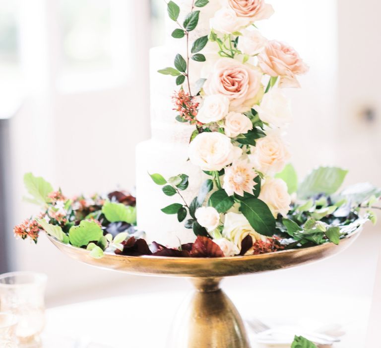 Classic wedding cake on gold cake stand decorated with flowers