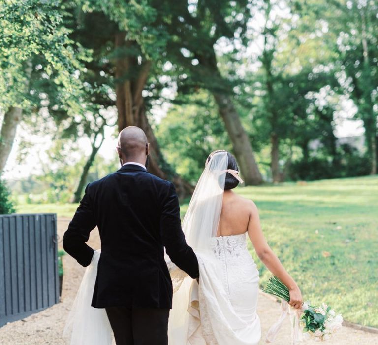 Groom helping his bride with her wedding dress train