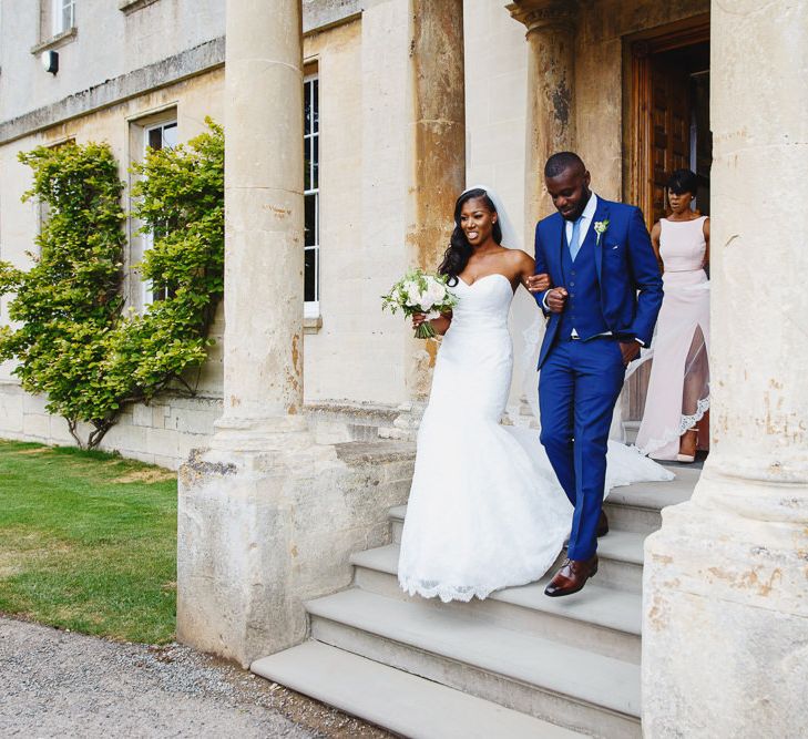 Bride in Lace Fishtail Gown with Strapless Sweetheart Neckline by Suzanne Neville | Lace Edged Cathedral Length Veil | Bridal Bouquet of White and Blush Roses and Peonies | Groomsman in Blue Three-Piece Ted Baker Suit | Mother of the Bride in Blush Pink Vera Wang Dress with Side Split | Peg Board Table Plan &amp; DIY Sweet Table for an Elmore Court Wedding | Mavric Photography