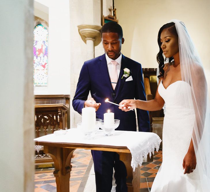 Bride in Lace Fishtail Gown with Strapless Sweetheart Neckline by Suzanne Neville | Lace Edged Cathedral Length Veil | Groom in Blue Three-Piece Ted Baker Suit with Blush Pink Tie | Wedding Ceremony at St John the Baptist Church, Elmore | Peg Board Table Plan &amp; DIY Sweet Table for an Elmore Court Wedding | Mavric Photography