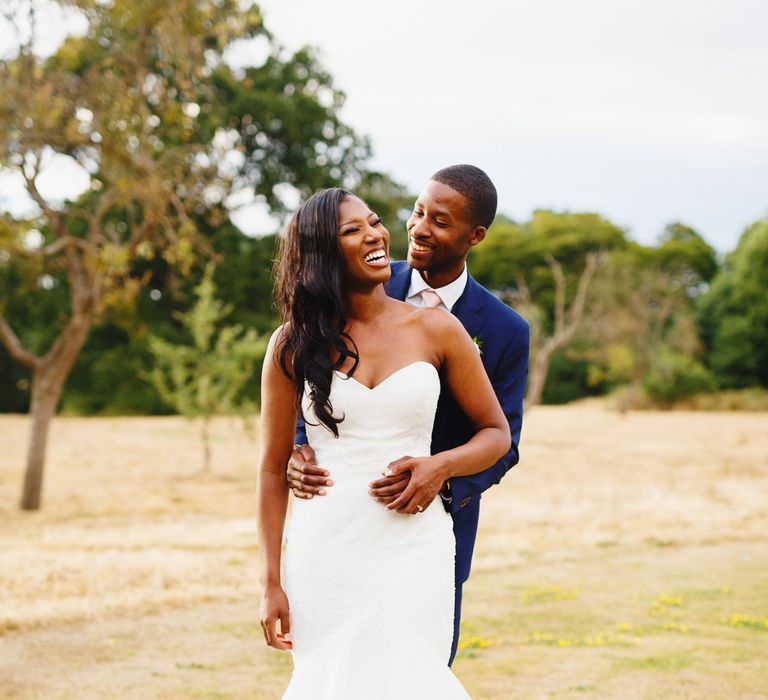 Bride in Lace Fishtail Gown with Strapless Sweetheart Neckline by Suzanne Neville | Groom in Blue Three-Piece Ted Baker Suit with Blush Pink Tie | Peg Board Table Plan &amp; DIY Sweet Table for an Elmore Court Wedding | Mavric Photography