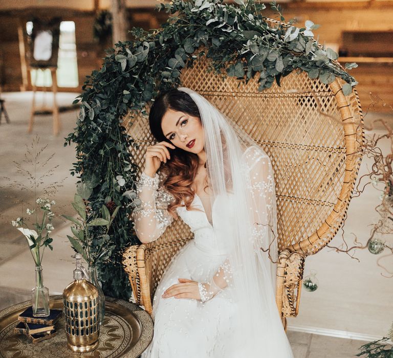 Bride on Peacock Chair Covered in Foliage | Geometric Wedding Decor &amp; Styling by Locate to Create at The Cherry Barn | Rebecca Carpenter Photography