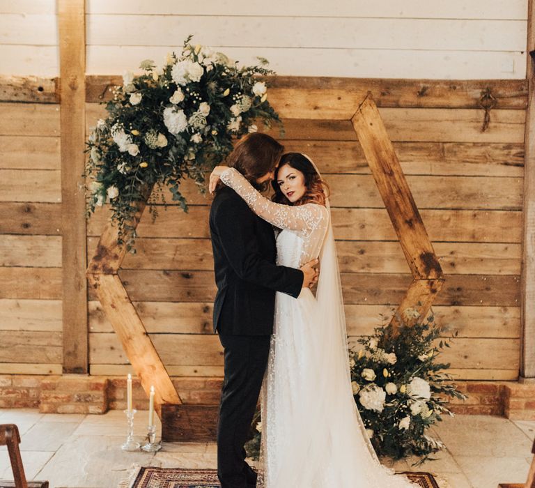 Boho Bride &amp; Long Haired Groom in Front of Hexagonal Moon Gate | Geometric Wedding Decor &amp; Styling by Locate to Create at The Cherry Barn | Rebecca Carpenter Photography