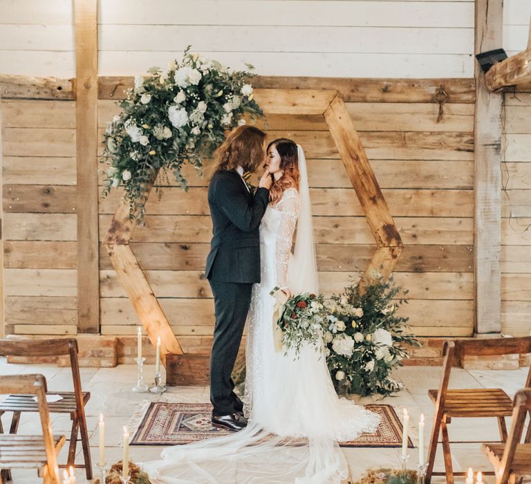 Boho Bride &amp; Long Haired Groom in Front of Hexagonal Moon Gate | Geometric Wedding Decor &amp; Styling by Locate to Create at The Cherry Barn | Rebecca Carpenter Photography