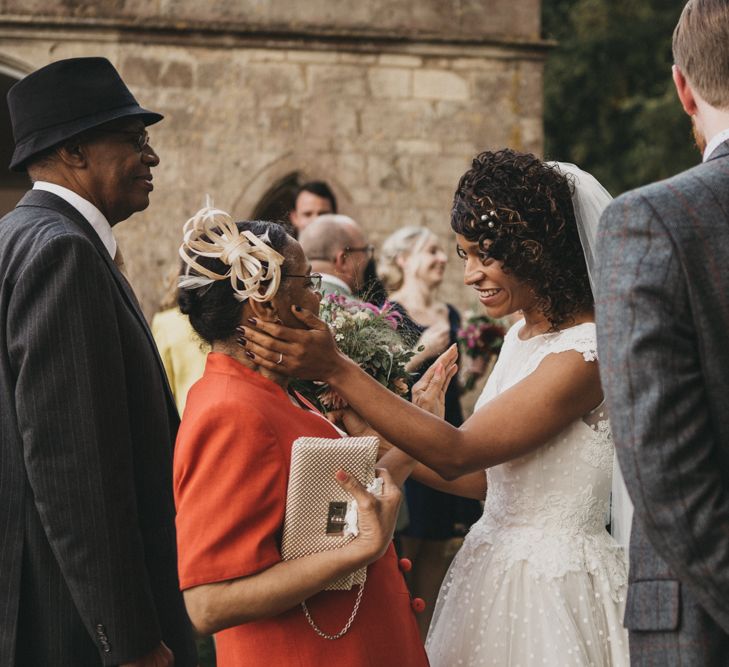 Bride in Polka Dot Wedding Dress with Curly Hair Greeting Wedding Guests