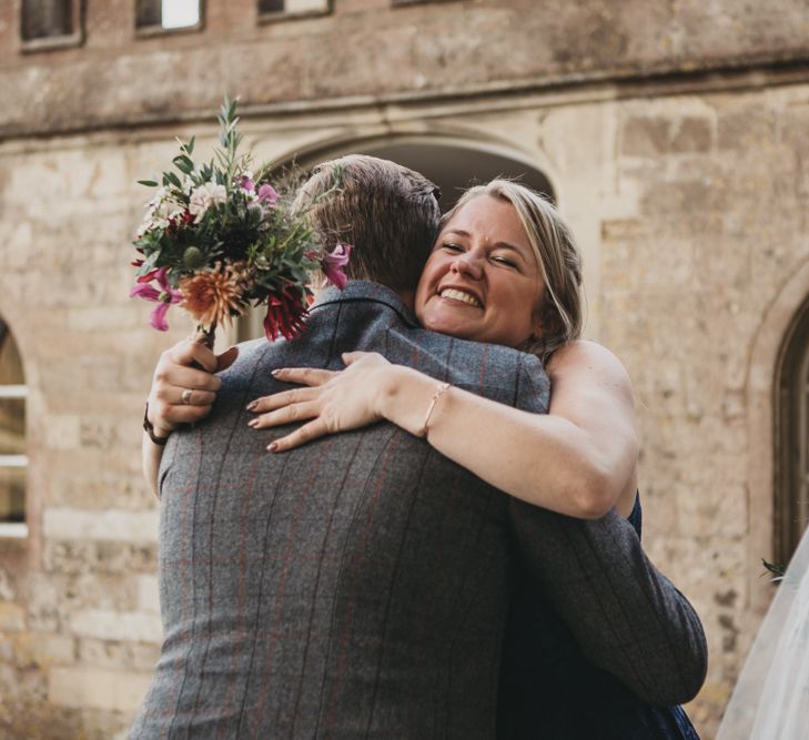 Bridesmaid Hugging the Groom in Grey Check Suit