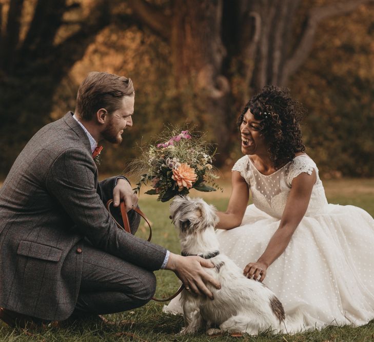 Bride in Polka Dot Tea Length Wedding Dress and Groom in Grey Check Suit with their Pet Dog