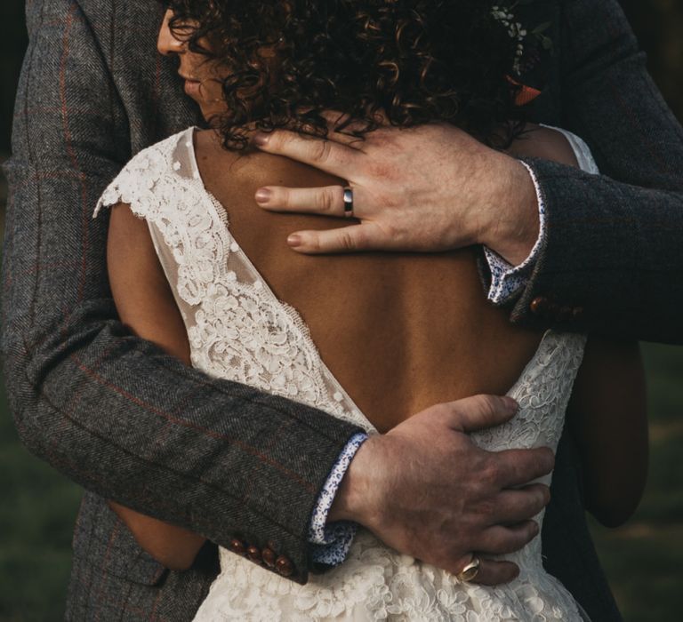 Groom Embracing His Bride in a V Back wedding Dress