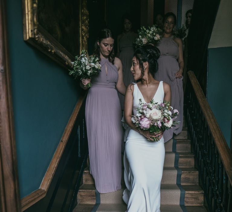 Bride Walking Down the Stairs in a Pronovias Wedding Dress with Her Bridesmaids