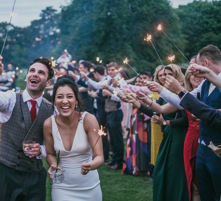 Sparkler Moment with Bride in Pronovias Wedding Dress and Groom in Plaid Waistcoat