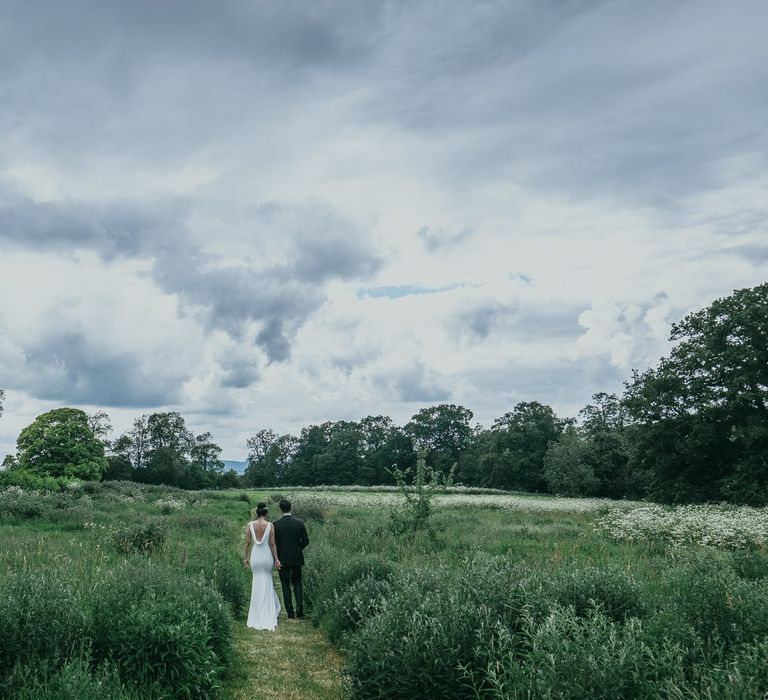 Bride and Groom Walking Through Elmore Court's Gardens