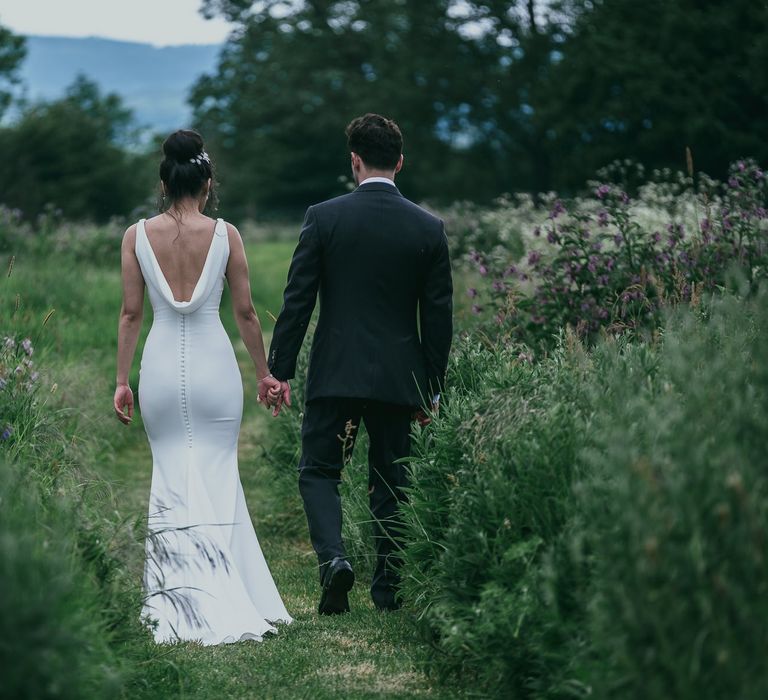 Bride in Fitted Pronovias Wedding Dress with Back Buttons and Cowl Detail and Groom in Cad &amp; The Dandy Suit