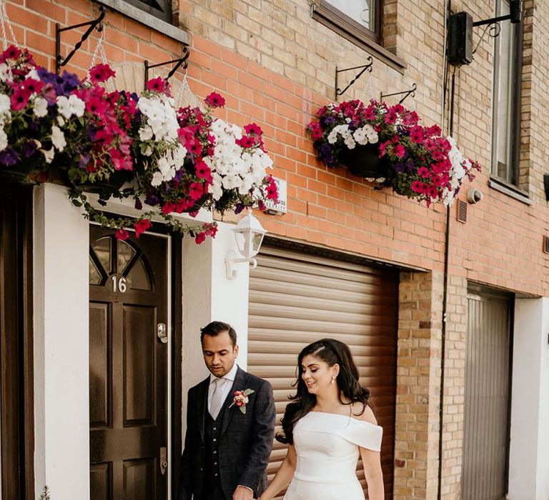 Bride and groom walking through London hand in hand