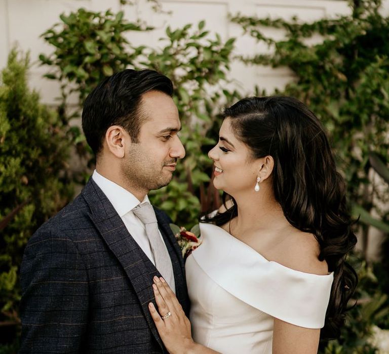 Groom in check suit and bride in off the shoulder wedding dress