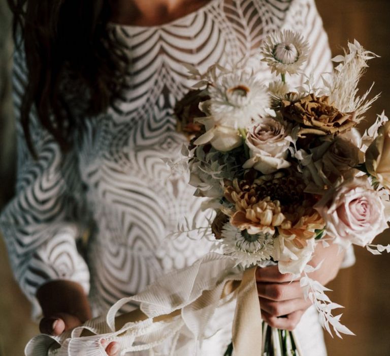 Bride in Margaux Tardits Wedding Dress with Swirl Pattern Holding Her Nude Wedding Bouquet Tied With Ribbon