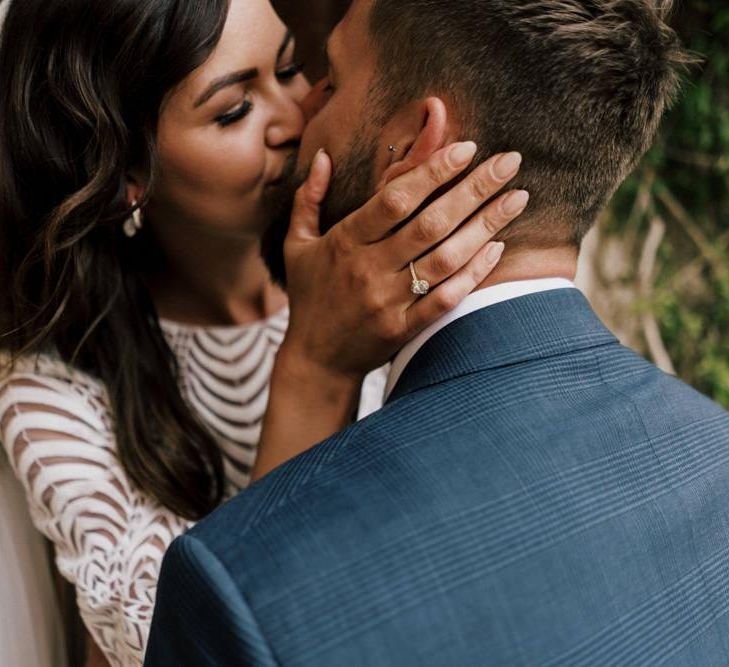 Bride Kissing Her Husband in a Navy Check Moss Bros. Wedding Suit