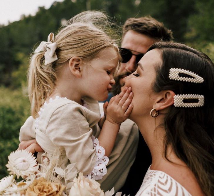 Bride with Pearl Hair Slides and young Daughter Sharing a Kiss