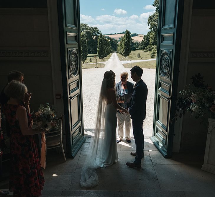 Bride and Groom Taking Their Vows in the Entrance on Pynes House