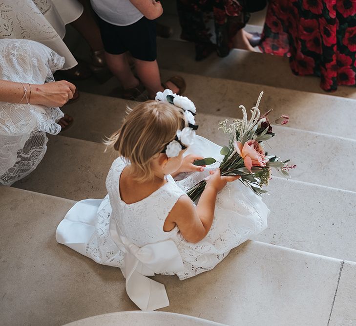 Flower Girl Sitting on The Steps Playing With Her Bouquet