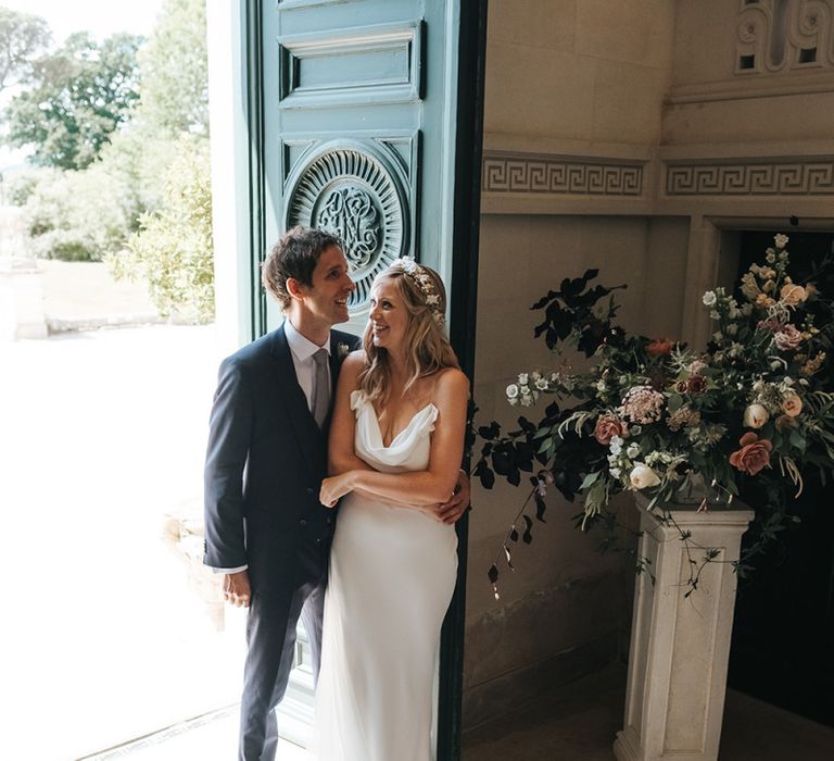 Bride in Savannah Miller Wedding Dress and Groom in Hugo Boss Suit Embracing During the Wedding Ceremony