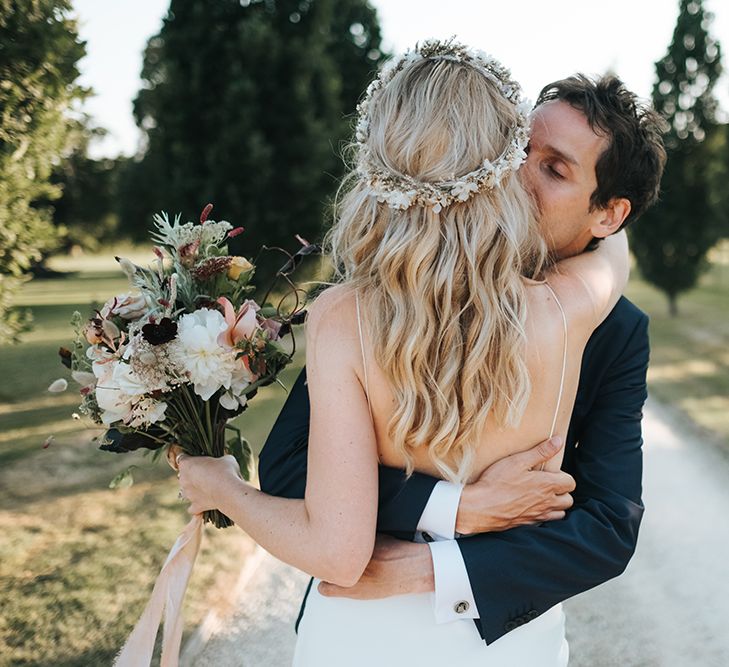 Groom Hugging His Bride Showing off Her Wavy Hair and Flower Crown