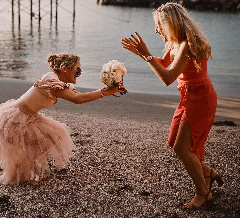 wedding guest in pink tulle dress catching the bouquet at Peters Beach Sorrento