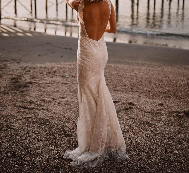 Bride in backless Enzoani wedding dress throwing the wedding bouquet