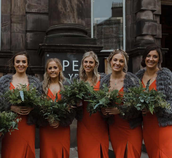 Bridesmaids in Burnt Orange Dresses with Charcoal Grey Loop Cardigans  and Greenery Bouquets