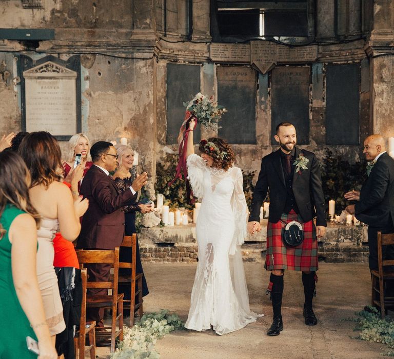 Bride in a Boho Rue De Seine Wedding Dress and Groom in Red Tartan Kilt  just Married Walking up the Aisle