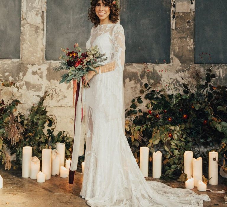 Boho Bride in Lace Rue De Seine Wedding Dress With Curly Hair Flower Crown and Red and Green Bouquet