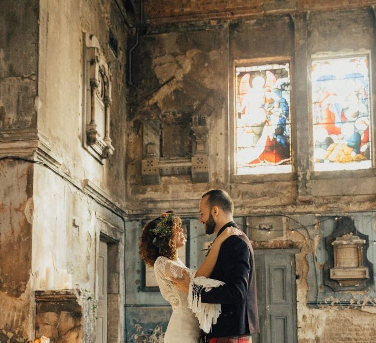 Boho Bride in Lace Rue De Seine Wedding Dress and Groom in Highland Wear Standing in The Asylum, London