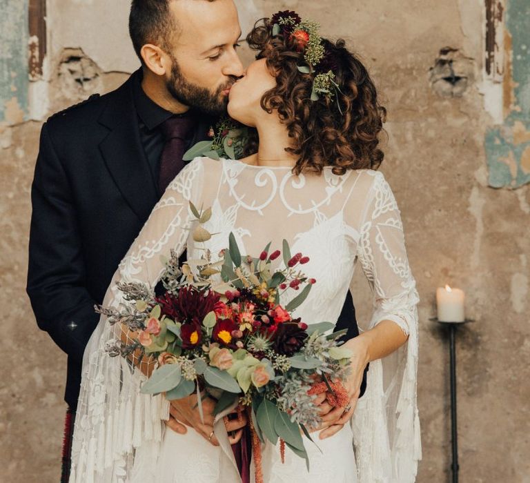 Bride in Lace Rue De Seine Wedding Dress  with Tassel Bell Sleeves and Groom in Highland Wear Kissing