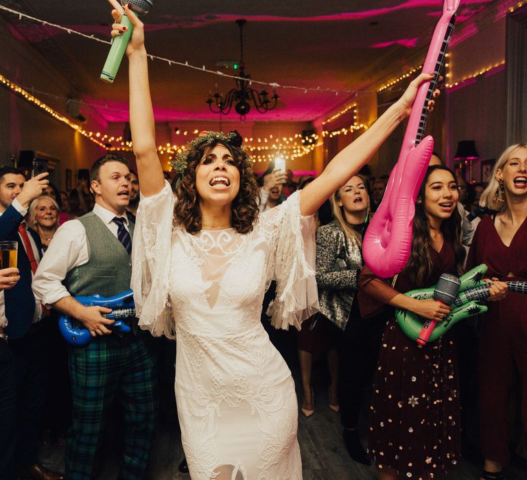 Boho Bride with Curly Hair &amp; Flower Crown Waving Inflatable Guitars on the Dance Floor