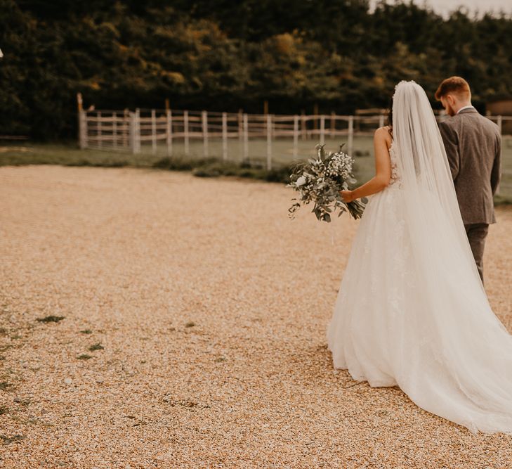 bride and groom walking through the grounds of their rustic wedding venue