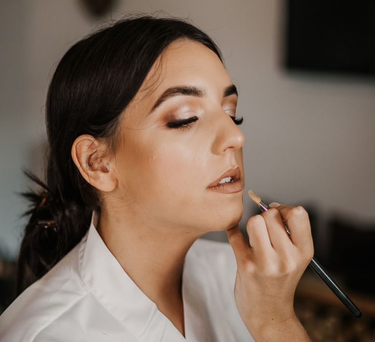 bride having her makeup done on the wedding morning