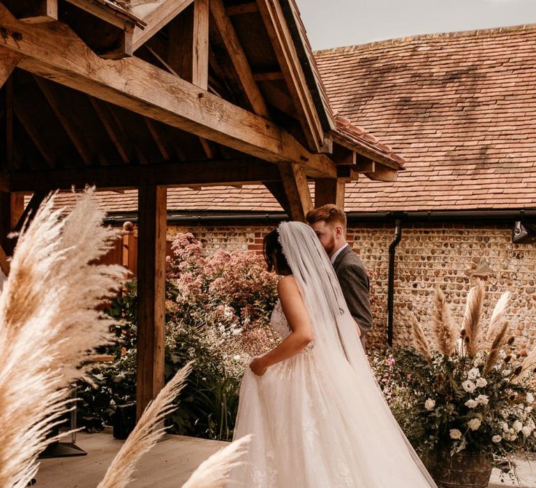 Bride wedding ceremony entrance in Enzoani wedding dress and cathedral length veil